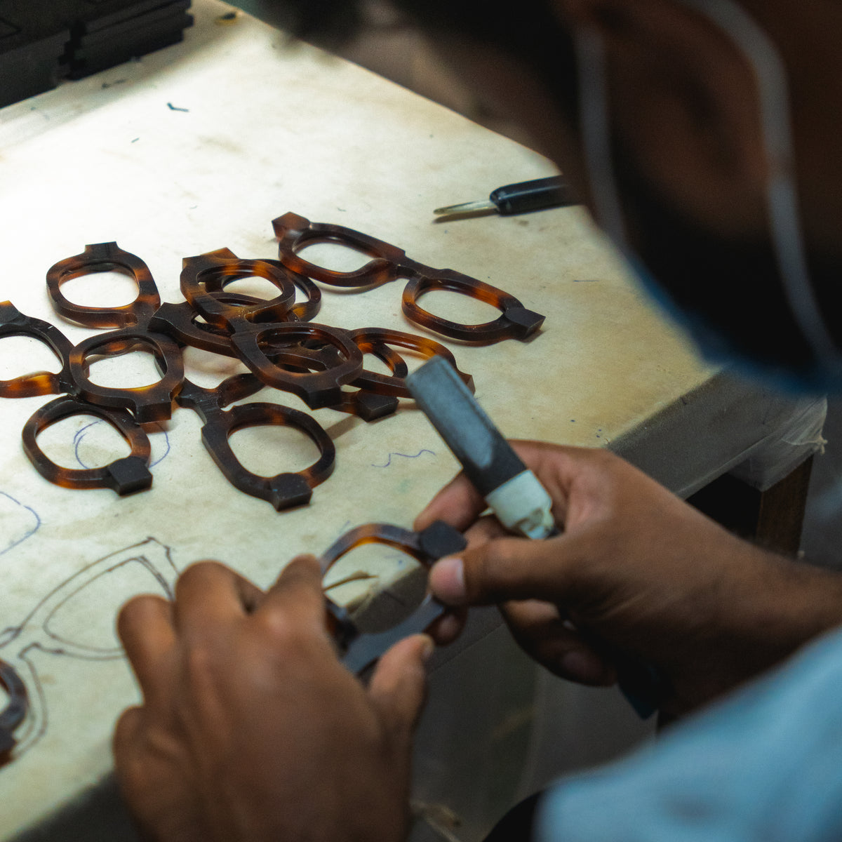 Hands refine a tortoiseshell frame front
